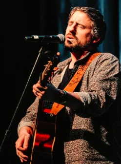Ryan Inglis performing live, eyes closed, at the microphone